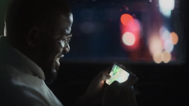 Hombre negro en coche en la ciudad por la noche — Vídeos de Stock