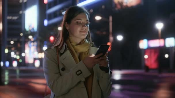 Donna che cammina in città con smartphone di notte — Video Stock