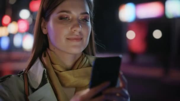 Mujer caminando en la ciudad con Smartphone en la noche — Vídeos de Stock