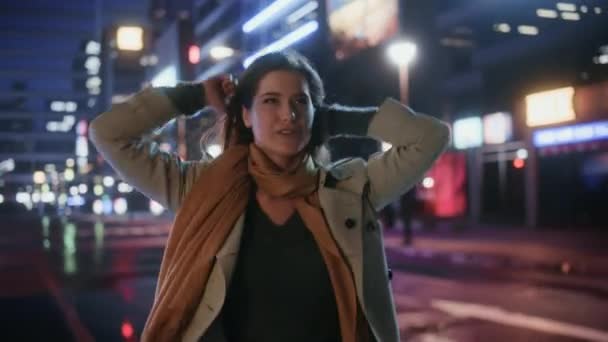 Mujer feliz caminando en la ciudad por la noche — Vídeos de Stock