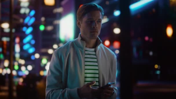 Людина користується смартфоном у нічному місті — стокове відео