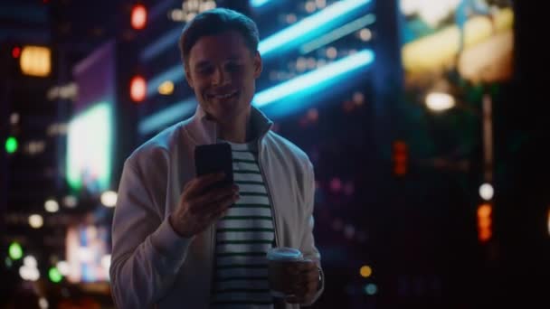 Mann benutzt Smartphone in nächtlicher Stadt — Stockvideo