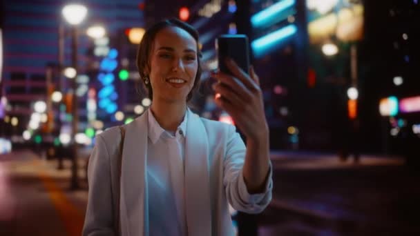 Femme utilisant un smartphone dans la ville de nuit — Video