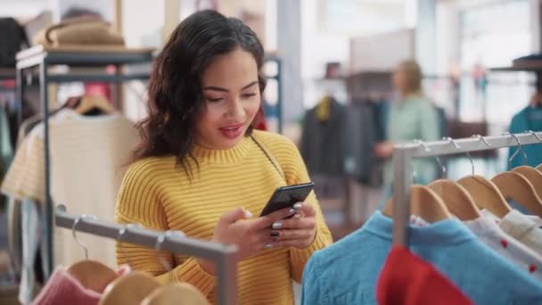 Cliente donna con Smartphone al negozio di abbigliamento — Video Stock