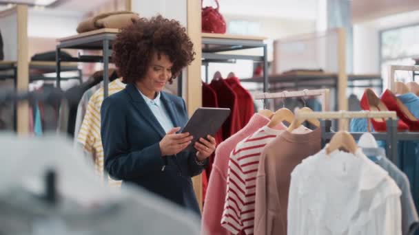 Asistente de ventas de tienda de ropa Trabajando con Tablet — Vídeo de stock