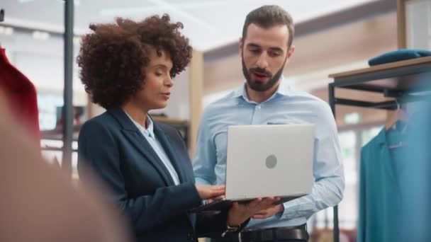 Zwei Verkäuferinnen im Bekleidungsgeschäft arbeiten mit Laptop — Stockvideo