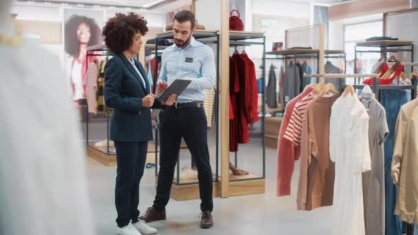 Deux assistants de vente de magasin de vêtements travaillant avec la tablette — Video