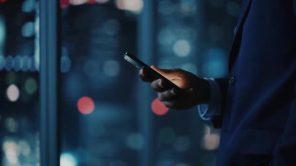 Бізнесмен використовує смартфон в офісі вночі — стокове відео