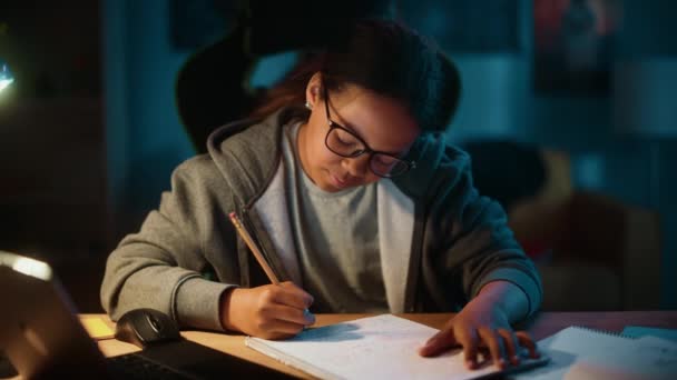 Junges Mädchen erledigt Hausaufgaben im Notizbuch zu Hause