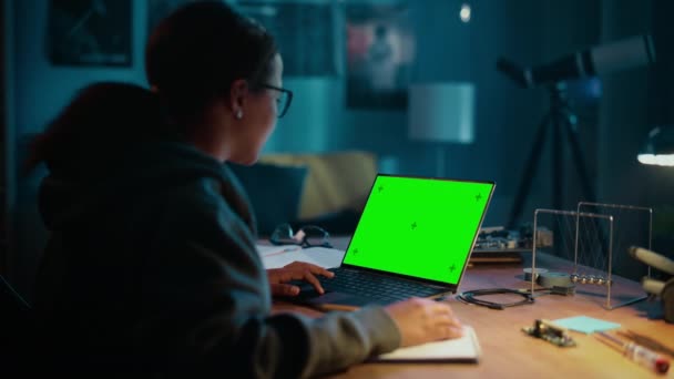 Školní dívka pracující na notebooku se zelenou obrazovkou