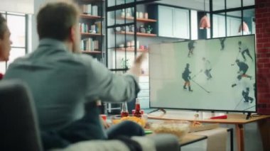 Spor hayranları TV 'de Hokey İzliyor