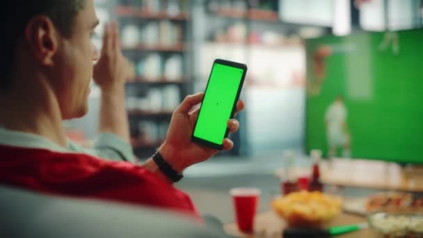 Sport fläkt använder grön skärm Smartphone klockor fotboll spel på TV — Stockvideo