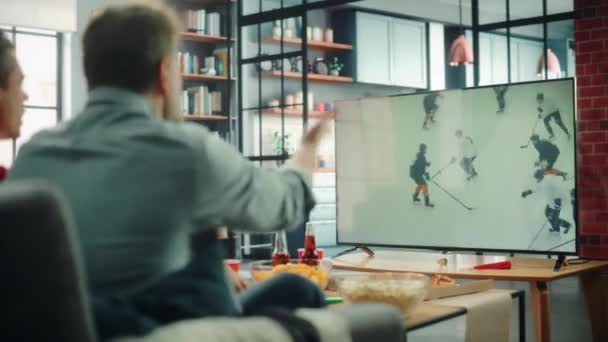 Sport fans kijken hockey op TV — Stockvideo