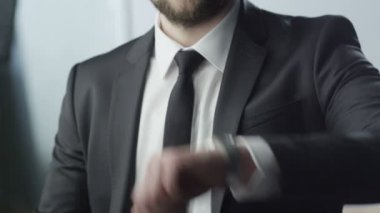 İş adamı saati kontrol ediyor.