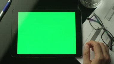 Yeşil ile işadamı kullanarak Tablet Pc ekran hangi Lying masanın üzerinde. Üstten Görünüm.