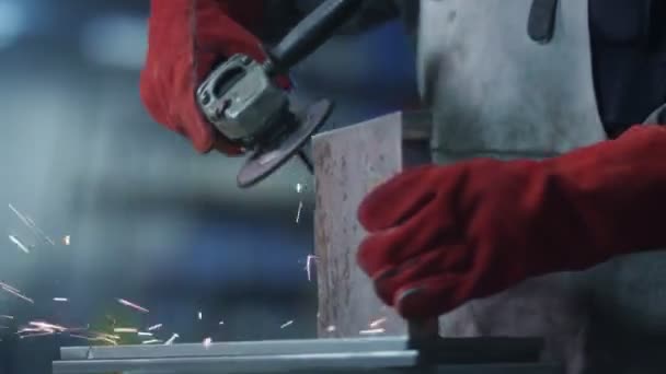 Работник с помощью углошлифовального станка на заводе — стоковое видео