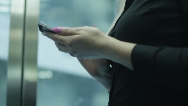 Mulher está usando telefone celular no elevador — Vídeo de Stock