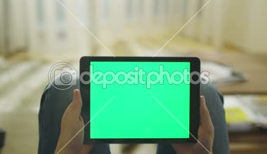 Döşeme evde kanepe ve Holding Tablet ile yeşil perde tur manzara modunda adamdır
