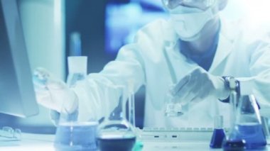 Bilim Adamı Laboratuvarda Kimyasal Reaktifleri Karıştırıyor.