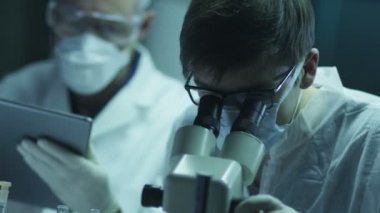 Bilim adamları takımız biyolojik araştırmalar yapıyor ve yazma veri içine Tablet.