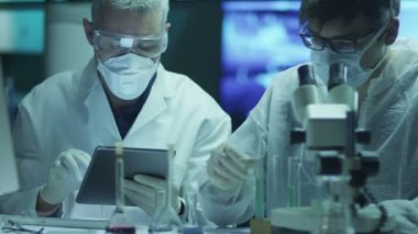 Bilim Adamları Ekibi Biyolojik Araştırmalar Yapıyor ve Tablete Veri Yazıyor