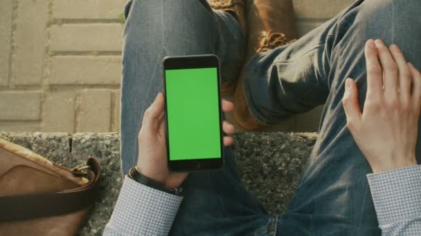 L'homme utilise le téléphone sur le tour à l'extérieur au jour ensoleillé. Point de vue — Video