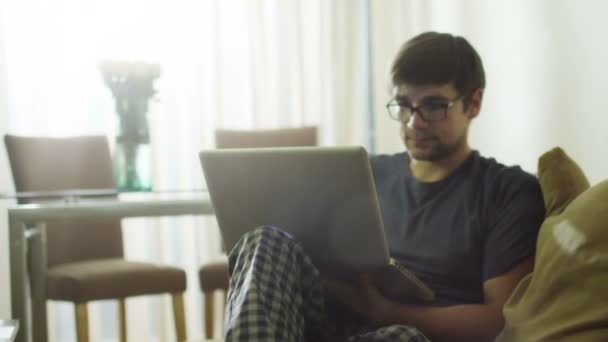Ο άνθρωπος είναι φορητό υπολογιστή χρησιμοποιώντας το πρωί στο σπίτι. — Αρχείο Βίντεο