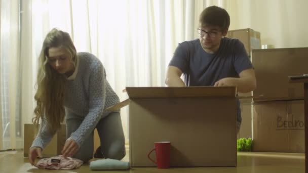 Couple is Unpacking Cardboard Boxes after Moving to New Flat — Stock Video