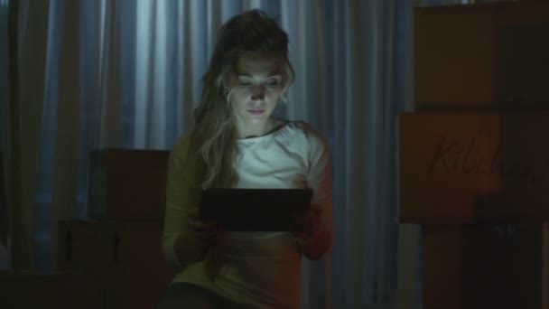 女孩是使用平板电脑的新房子在晚上 — 图库视频影像