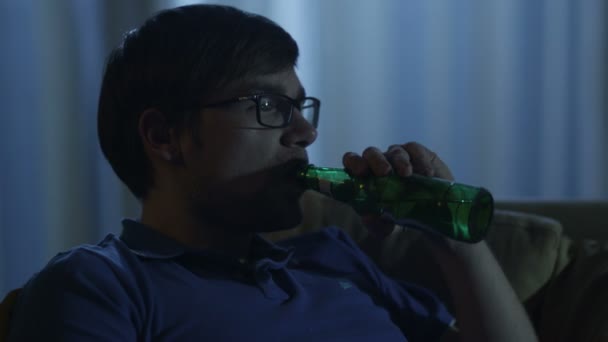 Homem está assistindo TV e bebendo cerveja à noite — Vídeo de Stock