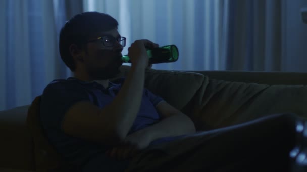 Mannen är titta på Tv och dricka öl på natt 2 — Stockvideo