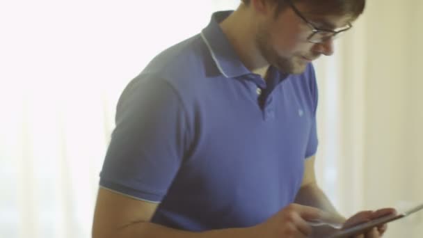 Человек использует планшетный компьютер дома на диване — стоковое видео
