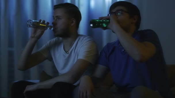 Amigos estão assistindo TV e bebendo cerveja à noite — Vídeo de Stock