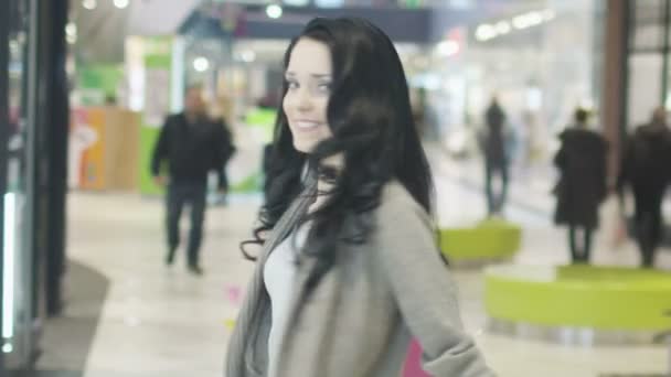 Portret van een jong meisje met zakken in winkelcentrum. Slow Motion. — Stockvideo