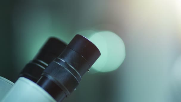 Junge Wissenschaftlerin schaut durchs Mikroskop — Stockvideo