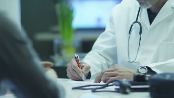Läkare skriver ut medicinska recept för patienten. — Stockvideo