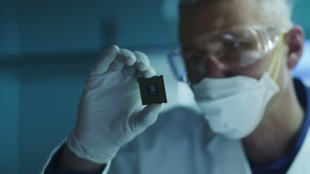 Ingeniero informático está sosteniendo e inspeccionando el chip del procesador — Vídeo de stock