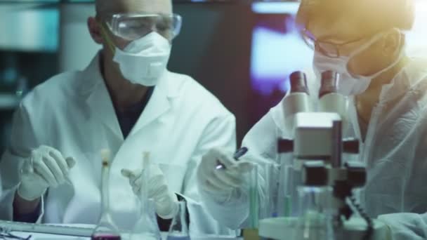 Team av forskare gör kemiska undersökningar och experiment i laboratoriet — Stockvideo