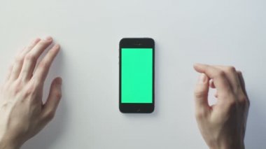 Beyaz Masa'ya Yeşil Ekranlı Cep Telefonu Koymak ve Kullanmaya Başlamak