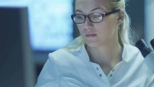 Mujer científica usando microscopio en laboratorio . — Vídeos de Stock