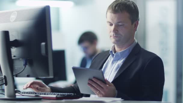 Trabajador de oficina está utilizando la tableta en el trabajo en la oficina — Vídeos de Stock
