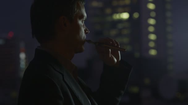 Uomo d'affari è fumare sigaretta elettronica alla sera — Video Stock