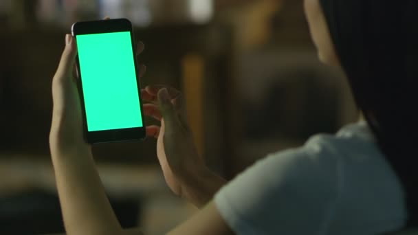 Tiener meisje gebruikt telefoon met groen scherm in portretmodus 's avonds. Casual Lifestyle. — Stockvideo
