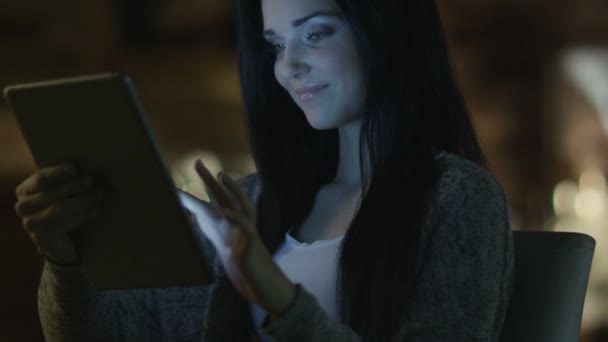 Chica adolescente con hermosa sonrisa está utilizando Tablet PC en la noche. Estilo de vida casual . — Vídeos de Stock