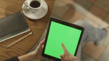 Tablet ile yeşil ekran kullanan kız. Omuz görünümü üzerinde.