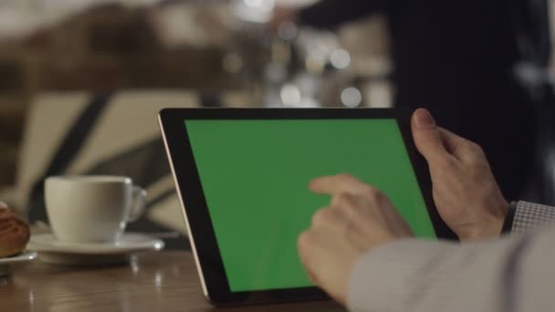 Людина за допомогою планшетного ПК у кафе. Табличка з зелений екран. — стокове відео