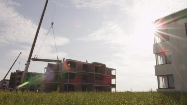 Grúa está levantando materiales de construcción en la construcción — Vídeo de stock