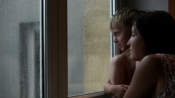 Menino com a mãe, olhando os pingos de chuva — Vídeo de Stock