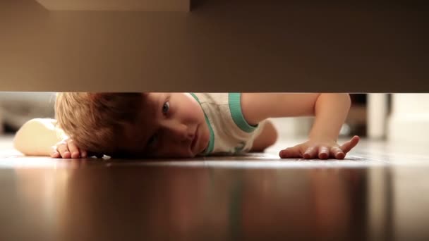 Маленький мальчик, глядя под кроватью — стоковое видео