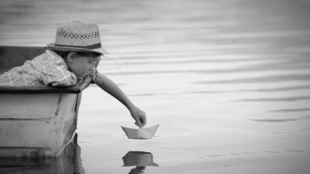 Мальчик настройки бумаги корабль паруса — стоковое видео